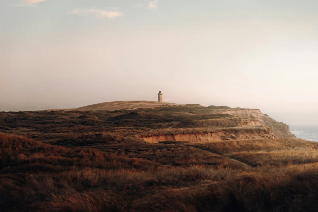 Råbjerg Knude Lighthouse on shifting sand dunes under a cloudy sky, photo by Daniel J. Schwarz